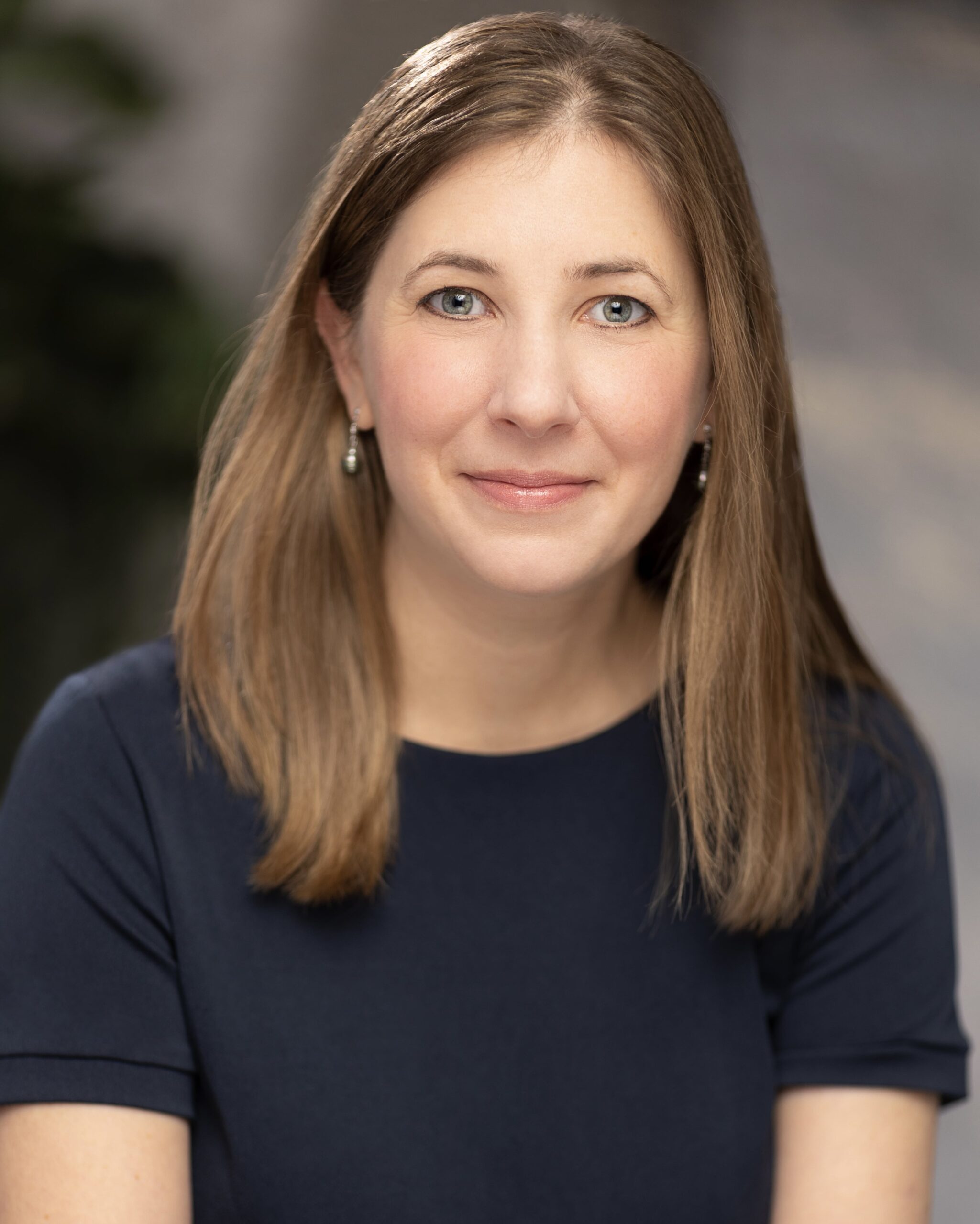 The author photo of a woman wearing a blue shirt and smiling.