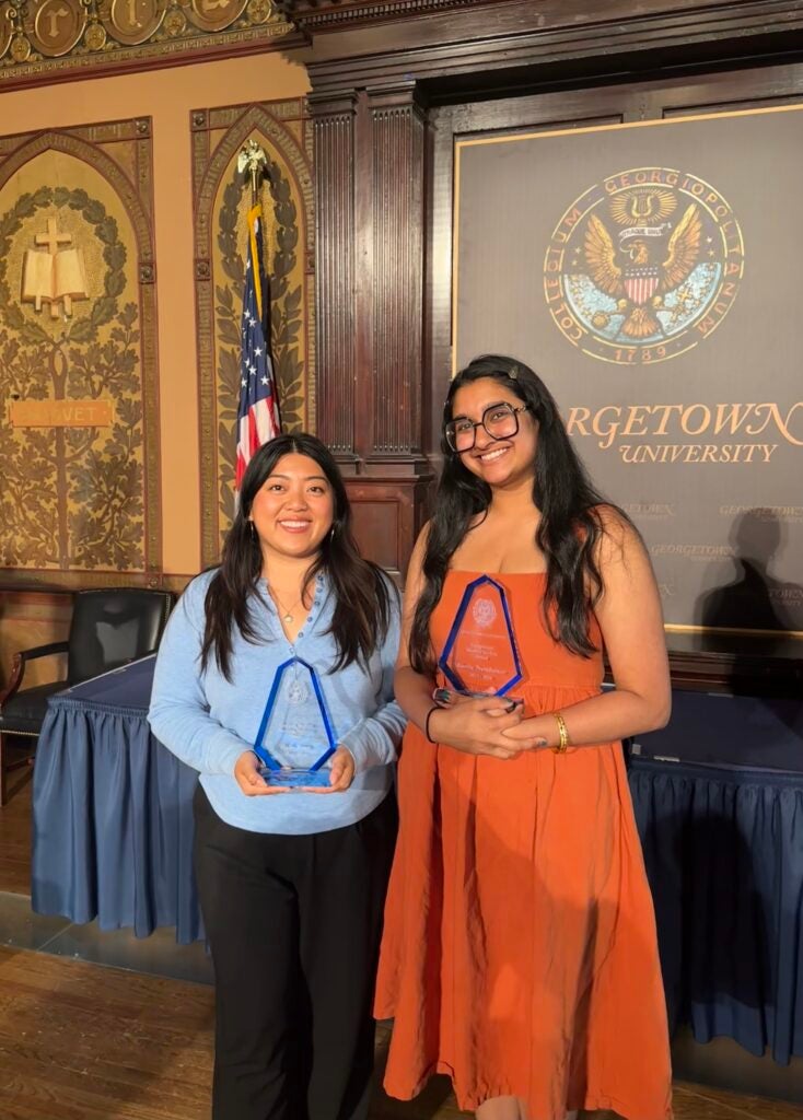 Halle Trang and Kavita Premkumar holding their awards in Gaston Hall