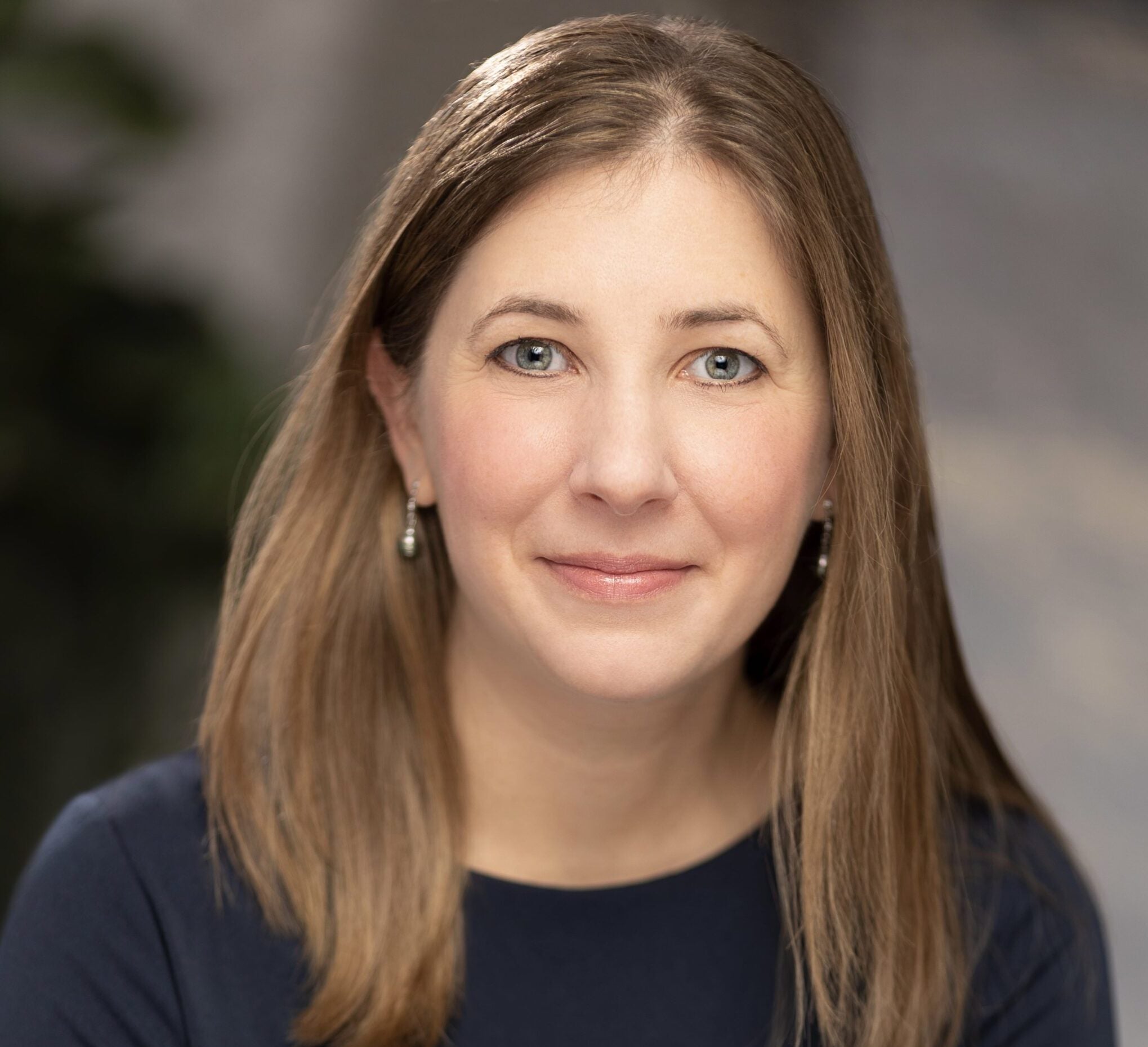 The author photo of a woman wearing a blue shirt and smiling.
