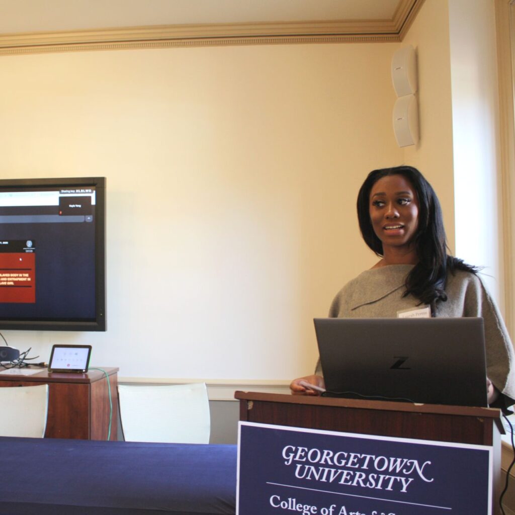 Laurah Perrin, MA '26, stands behind a lectern delivering her address to the EGSA conference