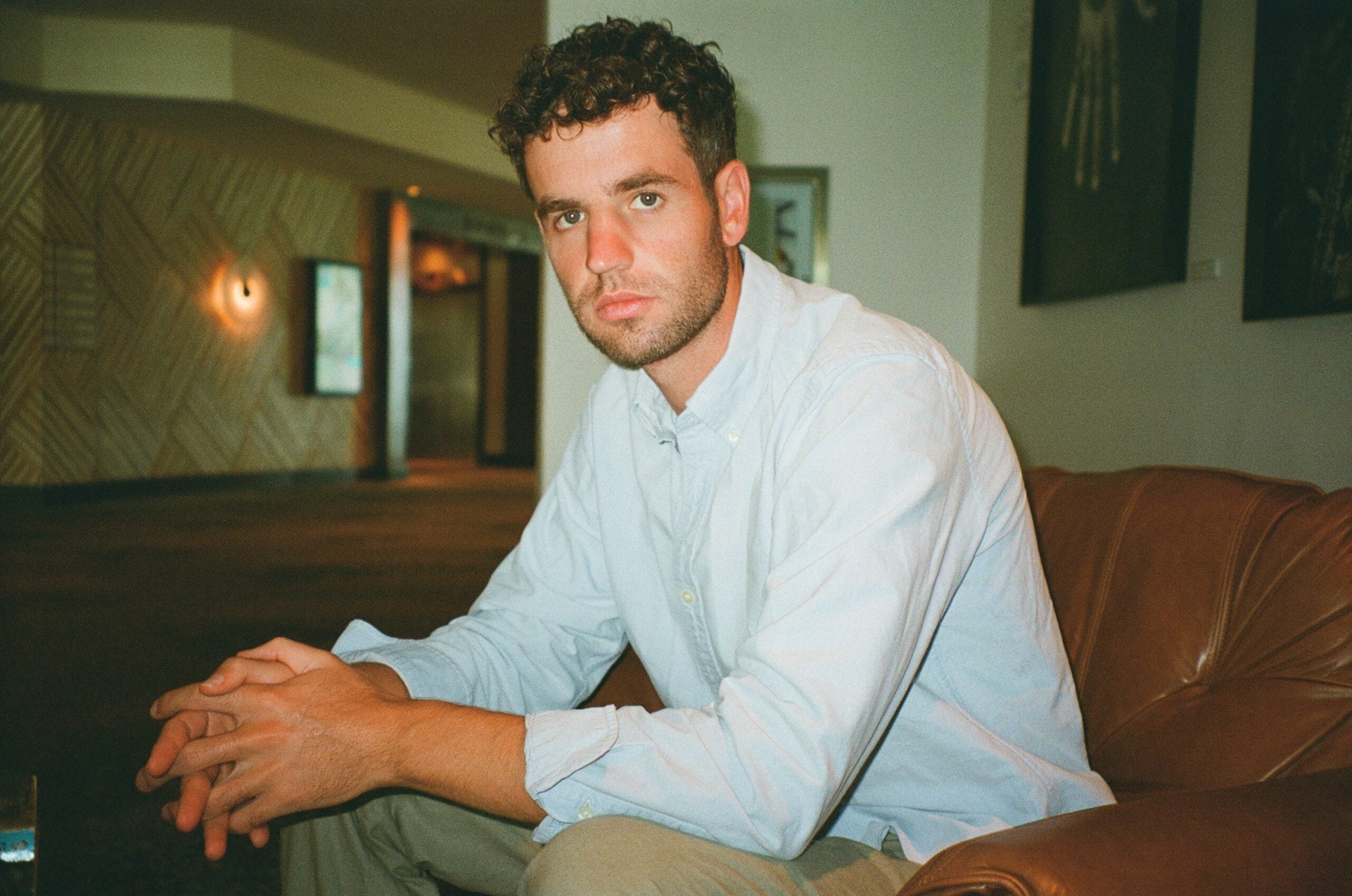 Dan Travers sits with his elbows on his knees and looks at the camera seriously