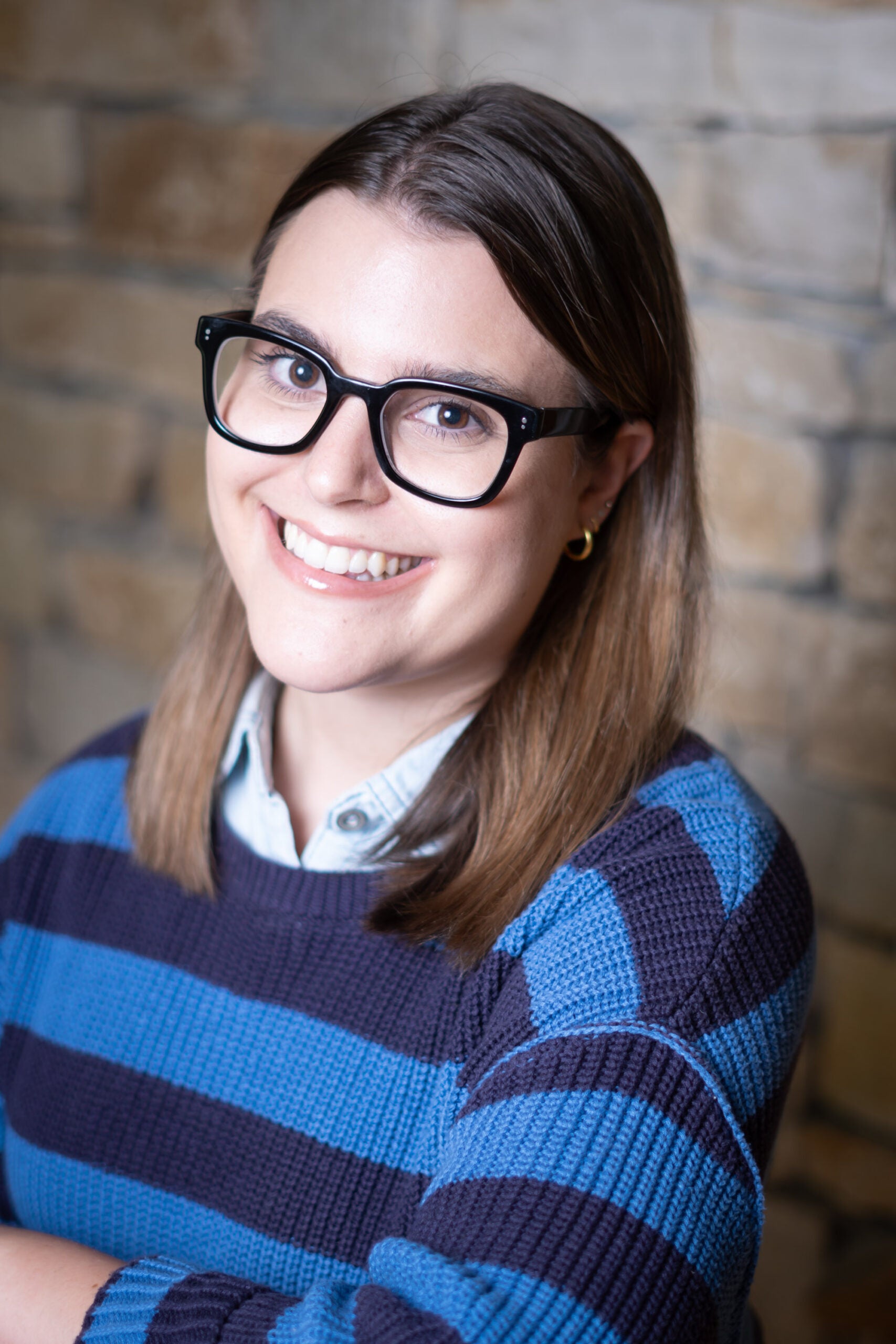 Isabelle Karpin smiles in a blue striped sweater and pale plue oxford shirt